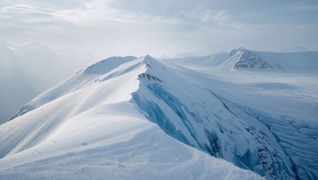 Wind-sculpted Snow Ridge Cutting Over Deep Crevasse on High-altitude Glacial Icefield Vista