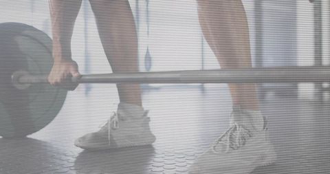 Closeup of Male Athlete Lifting Barbell with Bumper Plates on Rubber Gym Floor, Training