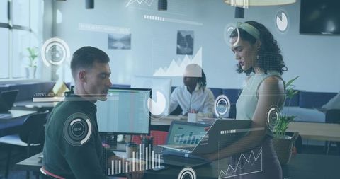 Coworkers collaborating and analyzing business data on laptops with interactive dashboards