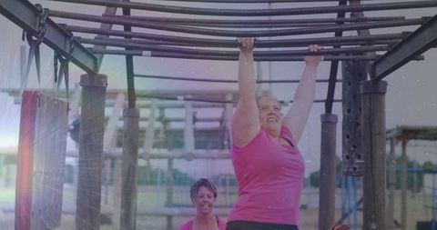Determined woman navigating monkey bars outdoors