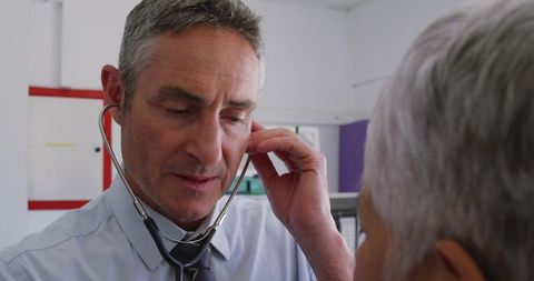 Doctor Using Stethoscope Examining Senior Female Patient