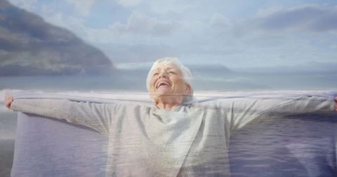 Joyful Senior Woman Enjoying Coastal View with Open Arms