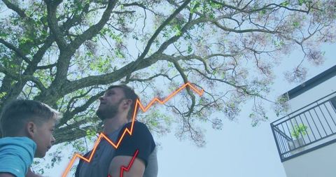 Father standing with son under tree with neon growth chart overlay in residential courtyard