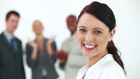 Smiling Businesswoman Receiving Praise from Colleagues