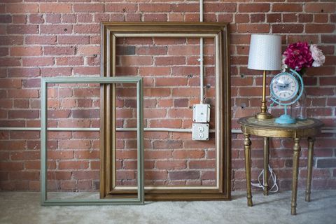 Eclectic interior with vintage frames and brick wall