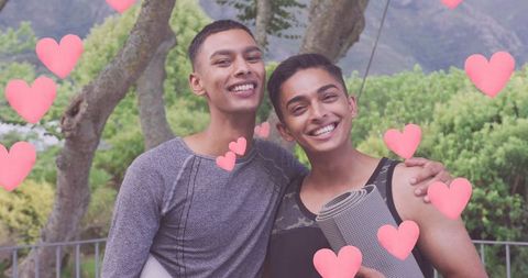 Mixed Race Male Friends Hugging Amidst Pink Heart Overlays Outdoors