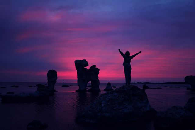 Silhouette of Person on Rock with Vibrant Sunset - Download Free Stock Photos Pikwizard.com