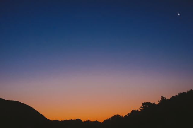 Scenic Twilight Sky with Crescent Moon and Silhouetted Hills - Download Free Stock Photos Pikwizard.com
