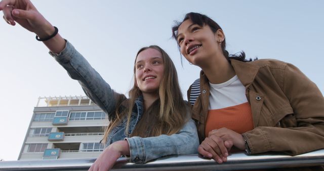 Two Teenage Girls Smiling and Pointing Outdoors - Download Free Stock Images Pikwizard.com