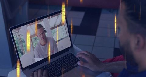 Working from home on laptop joining video call with headset-wearing participant on screen