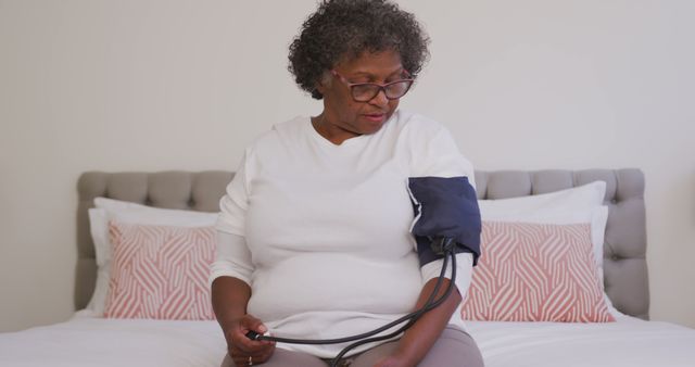 Elderly Woman Monitoring Blood Pressure at Home on Bed - Download Free Stock Images Pikwizard.com