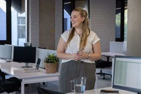 Woman enjoying break in modern open office workspace