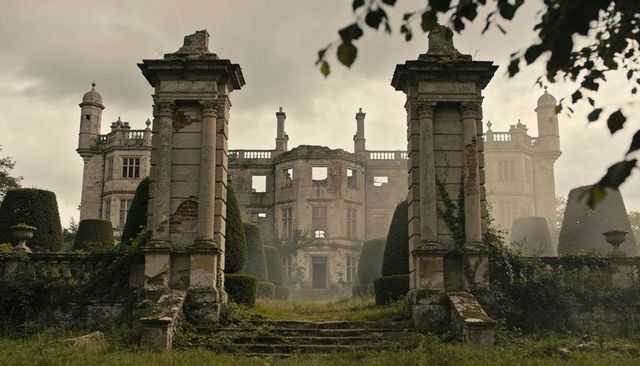 Crumbling georgian manor looming over overgrown terrace, ivyclad pillars, ruined facade
