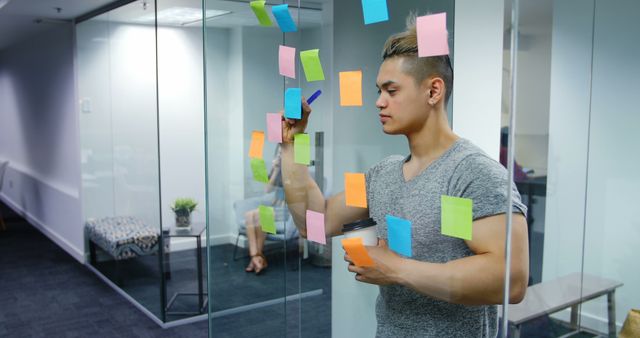 Young Professional Brainstorming Ideas with Sticky Notes on Glass Wall - Download Free Stock Images Pikwizard.com