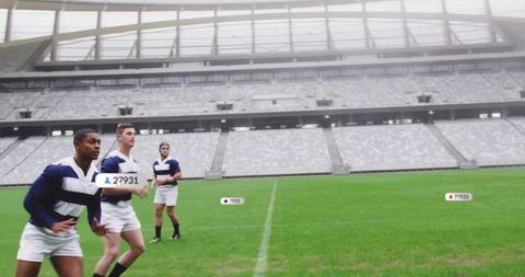 African american rugby player leading teammates running on stadium field showing teamwork