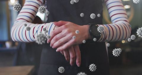 Hairdresser disinfecting hands with coronavirus cells overlay
