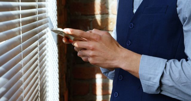 Businessman Typing on Smartphone Near Window with Blinds - Download Free Stock Images Pikwizard.com