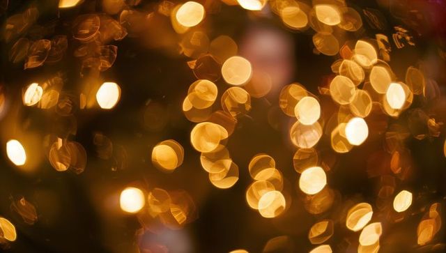 Creating warm golden bokeh lights casting soft amber glow for festive background