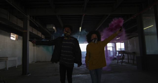 Young couple holding colored smoke and dancing in abandoned building - Download Free Stock Images Pikwizard.com