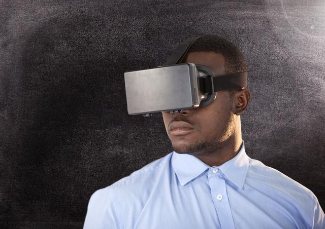 Close-up of man using virtual reality headset against grey background