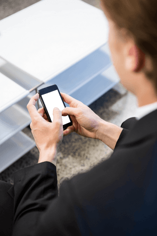 Businessman using smartphone with transparent screen indoors