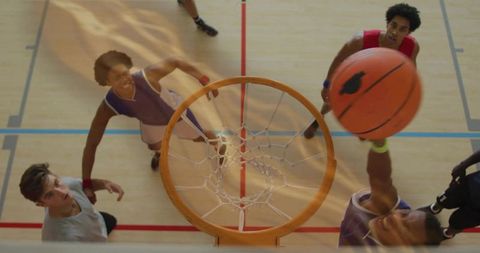 Teen Athletes Dunking Basketball Indoors with Team Spirit