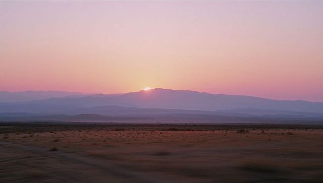 Peaceful Sunrise over Desert Mountain Range Silhouette
