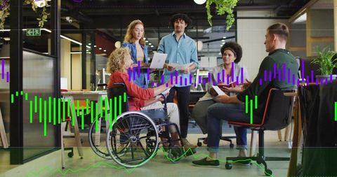 Inclusive team collaborating in modern open office with wheelchair, laptop, data overlay