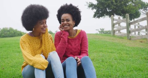 Joyful Young Women Relaxing on Grass in Park