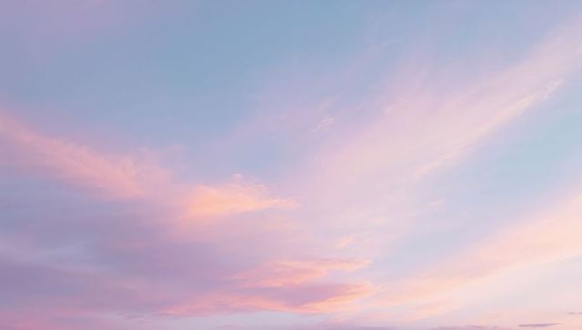 Pastel sunrise sky filling frame with lavender peach clouds and serene dawn gradient