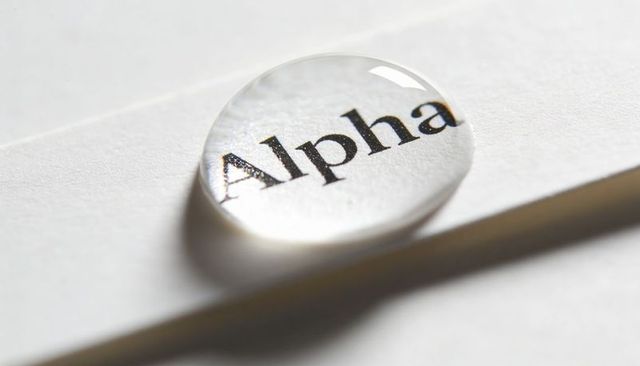 Macro water droplet magnifying word alpha on textured paper showing optical clarity focus