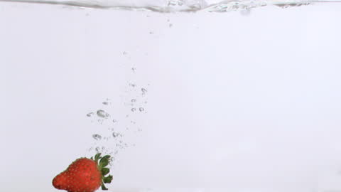 Strawberry Falling into Water with Splash and Bubbles
