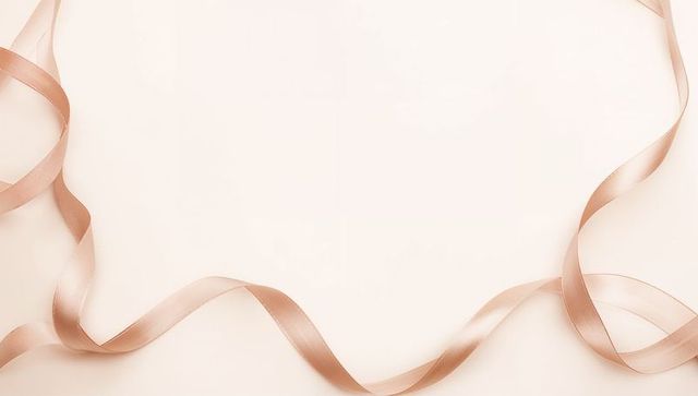 Rose gold satin ribbon curling on pale cream backdrop for luxury minimal design