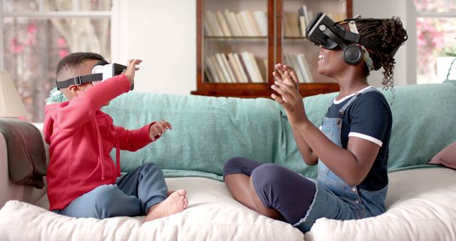 Two children sitting on couch wearing VR headsets, engrossed in a virtual reality game. Ideal for content related to family entertainment, modern technology, kids' gadgets, and VR gaming experiences.