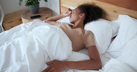 Woman Resting Peacefully in Bed with Minimalistic Interiors