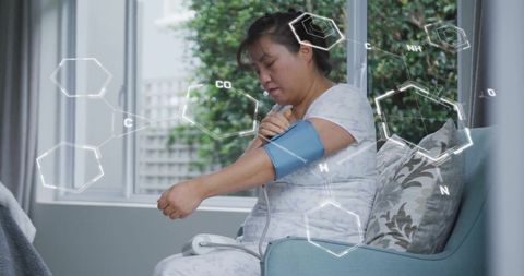 Woman checking blood pressure with digital data overlay