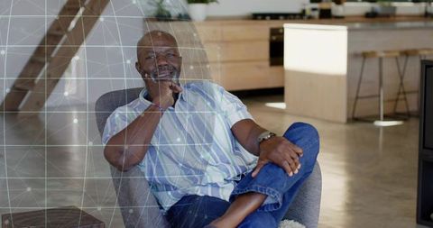 Senior man relaxing in modern minimalist living room with geometric network overlay