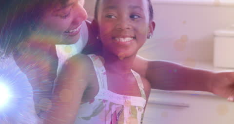 Joyful Mother and Daughter Bonding in Kitchen Glow