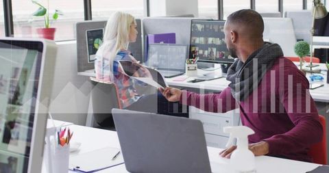 Man handing document to colleague in modern open-plan office with analytics visual overlay