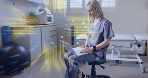 Medical professional working on laptop in clinic with futuristic elements