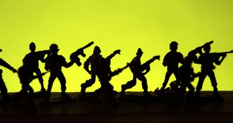 Silhouetted Toy Soldiers on Vibrant Yellow Background - Download Free Stock Images Pikwizard.com