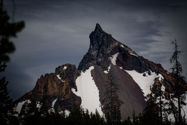Striking image of a snow-capped mountain peak during twilight hours, capturing the dramatic and rugged beauty of nature. Ideal for travel brochures, outdoor adventure promotions, landscape photography collections, and nature-themed website designs.