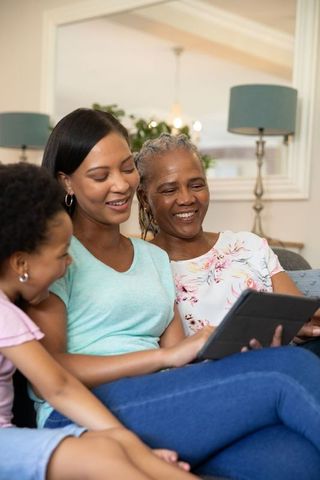 Three-Generation Family Bonding on Sofa with Tablet in Living Room