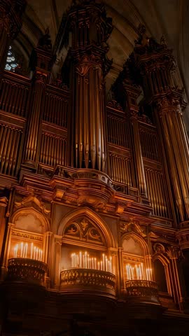 Vertical cathedral organ reveal tilting from candle racks to towering Gothic pipe facade