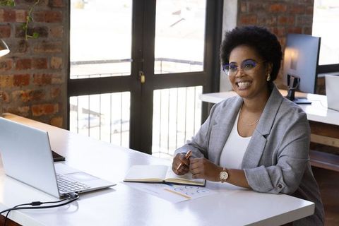 Confident Professional Woman Working at Modern Office Desk