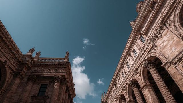 Classical stone facades framing blue sky with corinthian columns and ornate arches