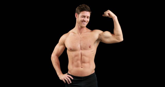 A young Caucasian man is showcasing his muscular physique and flexing his bicep, with copy space. His confident pose and smile suggest a focus on fitness and strength.