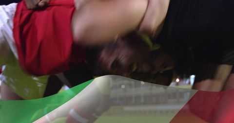 Night rugby players colliding in scrummage on turf with flag overlay and motion blur
