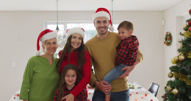 Smiling Family Celebrating Christmas, Wearing Santa Hats in Living Room - Download Free Stock Images Pikwizard.com