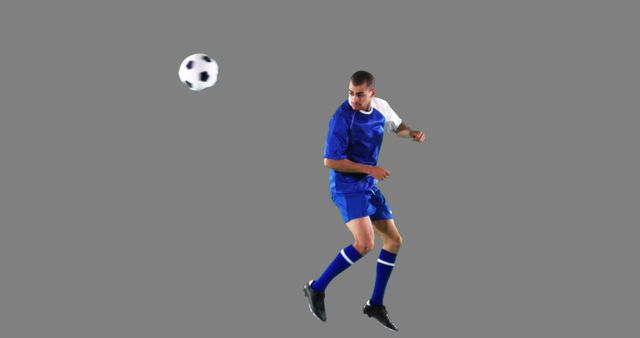 Football player wearing blue and white jersey heading soccer ball. Perfect for sports-related promotions, athletic club advertisements, training manuals, and fitness campaigns.